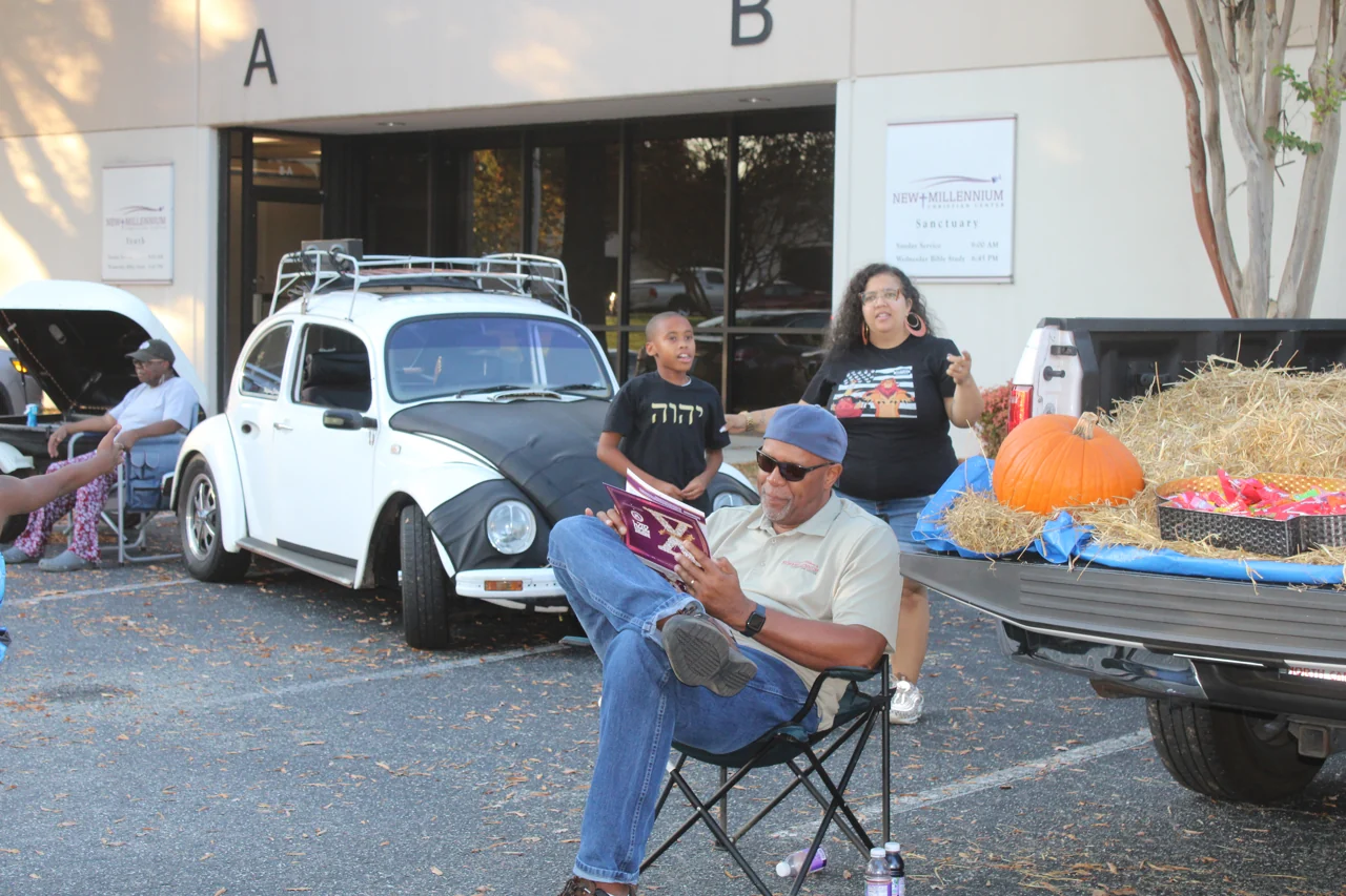 People gathered beside a decorated vehicle outdoors