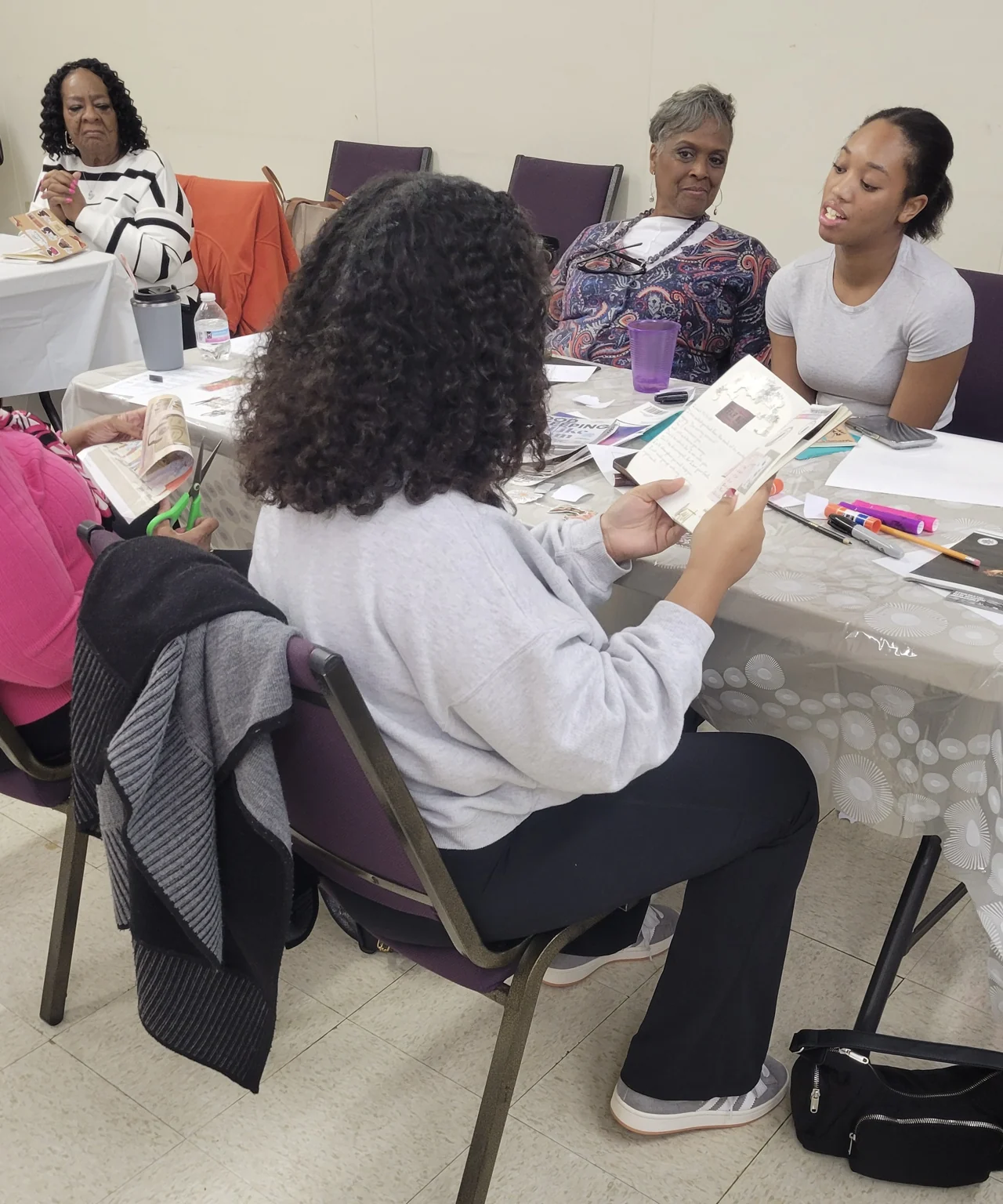 People gathered around a table with printed materials